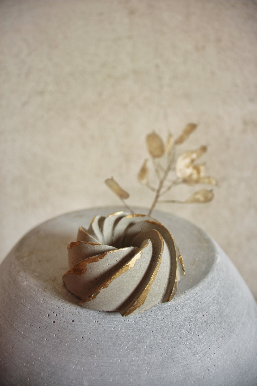 Zlacený betonový stojánek na kónickou svíčku "bábovička"